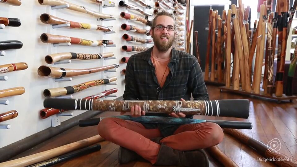 Didgeridoo buyers guide presenter seated with a didgeridoo across his lap
